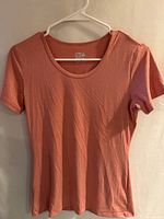 Front view of pale orange short-sleeve T-shirt on hanger