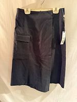 Front view of black skirt on hanger showing overall style and length