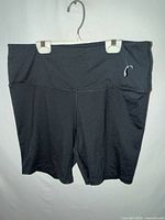 Front view of black athletic shorts on hanger