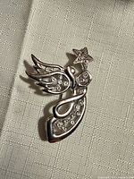 Front view of silver tone angel brooch showing crystal accents and shape