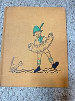 Front cover showing cloth boards, illustration of boy with accordion and cat