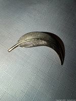 Front view of goldtone leaf brooch showing overall shape and engraving detail