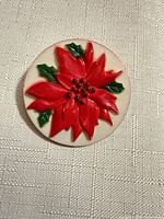 Front view showing full red poinsettia motif on white disc pin