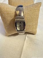 Front view of Vivani silver-tone watch on display cushion