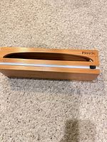 Top view of wood dispenser showing oval opening and cutter bar