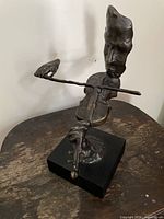 Front view showing bronze figure with violin and bow on black base