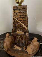 Full view of carved wood lamp base with brass socket