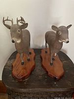 Front view of both carved deer on bases