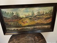 Front view of framed oil painting with two deer in landscape