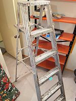 Full view of folded 6-ft aluminum A-frame step ladder showing five steps and top platform