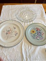 All three items laid out: two ceramic plates and one clear glass pie plate