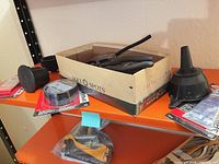 Group shot showing funnels, adapters, SpiderPatch pack, strap wrench in box on shelf