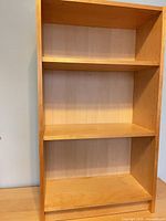 Front view of light maple Billy bookcase showing three shelves