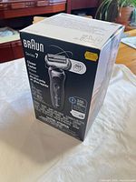 Front of boxed Braun Series 7 shaver showing model, color, SmartCare station image and 360 Flex feature