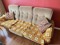 Full view of sofa with afghan and pillows