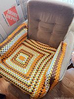 Front view of armchair showing crochet throw
