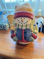 Front view of ceramic snowman cookie jar with hat, scarf and broom