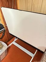 Front view of drafting table showing white surface and metal base