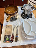 Overview of both fondue pots, forks and plates