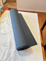Rolled grey-blue yoga mat on table