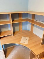 Overall view of desk showing upper and lower shelves, manual on work surface