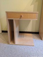 Front view showing drawer, knob, open lower shelf