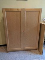 Front view of light maple veneer cabinet with two doors