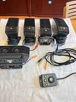 Four satellite speakers, one center satellite, control pod, cables