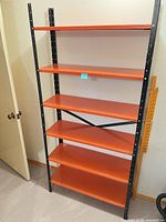 Full view of entire shelving unit showing six orange shelves and black frame