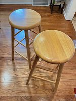Two matching solid wood bar stools showing entire form