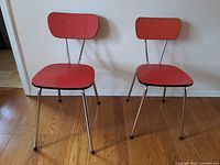 Pair of red laminate chrome chairs side by side