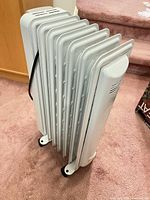 Full side view showing seven fins, casters and power cord