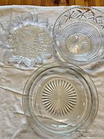 Top view showing all three glass bowls: starburst platter, diamond pattern bowl, winter scene ruffled bowl