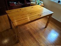 Top view of rectangular pine dining table showing honey finish and wood grain
