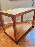 Three-quarter view showing overall cart structure, wood grain, casters