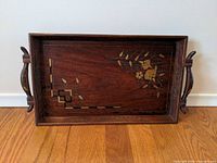 Top view showing brass/metal floral and geometric inlay and handles