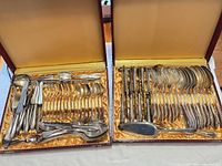 Open cases showing entire 72-piece silver-plated flatware set