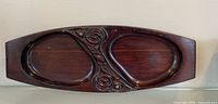 Full view of wooden dish front showing two compartments and carvings
