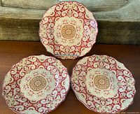 Three matching paisley patterned salad plates displayed