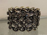 Front view of pewter-tone rhinestone bracelet showing swirl links and crystals