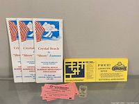 Group shot showing three brochures, yellow coupon, and pink tickets