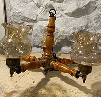 Chandelier side view showing wood column and glass shades