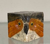 Front view showing owl face, yellow eyes and stone coloration