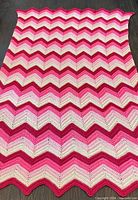 Afghan blanket laid flat to display full chevron pattern and size