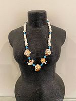 Necklace displayed on bust showing overall design and length