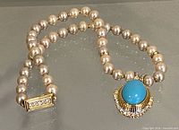 Full view of pearl necklace showing clasp and pendant