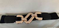 Full view of black elastic belt with pearl-beaded gold-tone triple link buckle