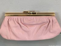 Front view of pink leather clutch showing gold-tone frame and clasp