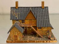 Angled front view showing main cottage, side shed, base landscaping