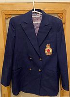 Full front view of navy double-breasted blazer on hanger